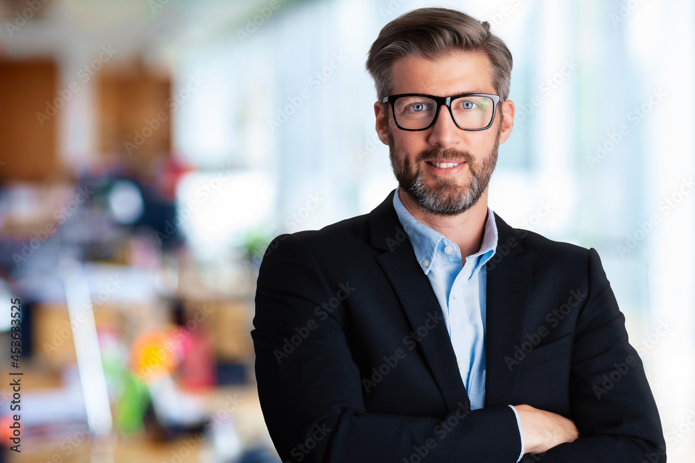 Handsome businessman wearing eyeglasses and suit while standing at the office Handsome businessman wearing eyeglasses and suit while standing at the office