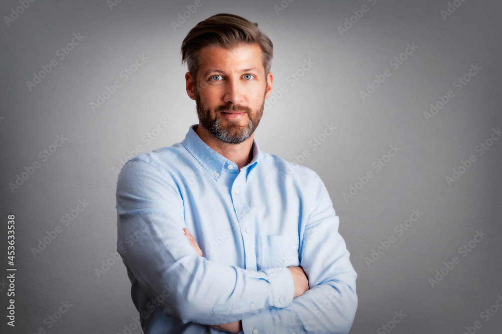 Studio shot of confident businessman standing with arms crossed at isolated background Studio shot of confident businessman standing with arms crossed at isolated background