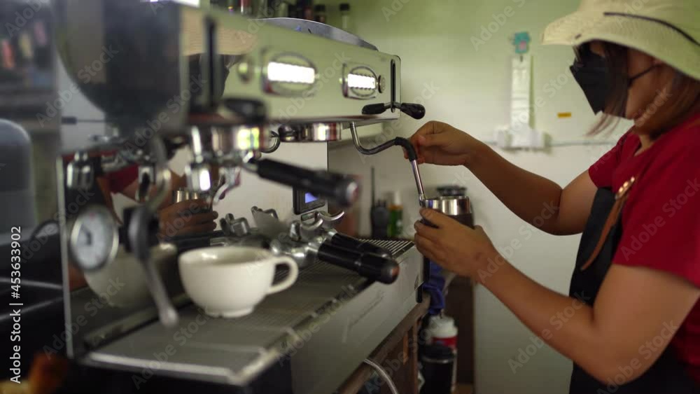 Coffee worker using a large coffee machine in a café. Coffee worker using a large coffee machine in a café.