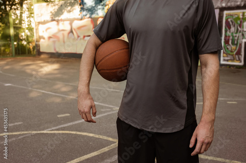 Young man playing with a basketball outdoors. Sports concept