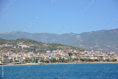mediterranean town alanya with mountain and blue sky background, view from the sea to coastline