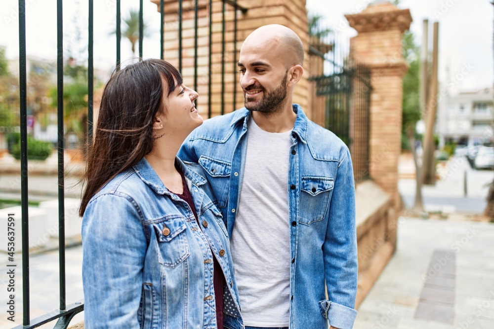 Young hispanic couple smiling happy standing at the city.