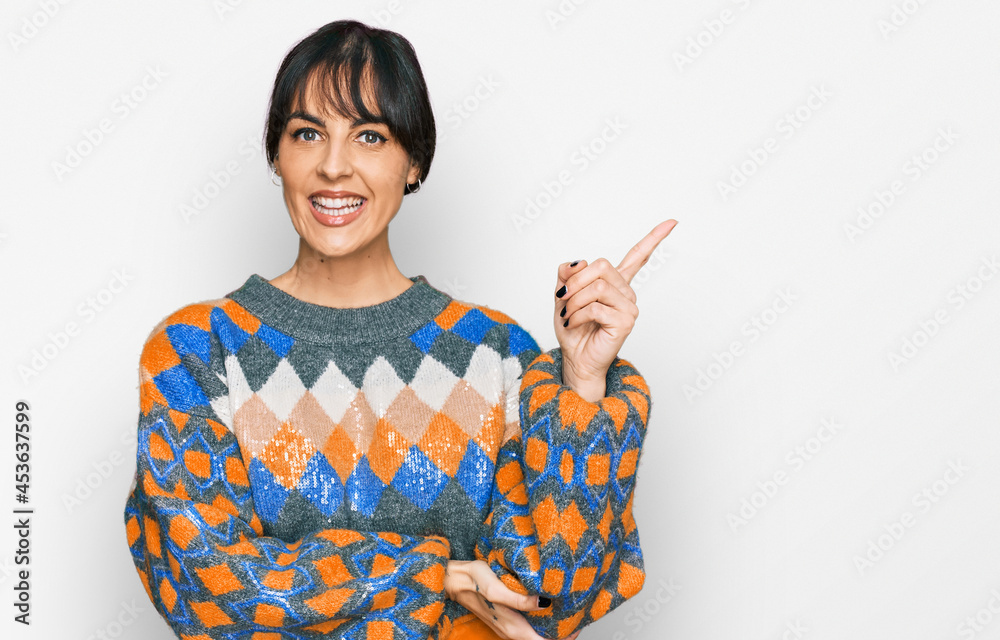 Young hispanic woman wearing casual clothes smiling happy pointing with hand and finger to the side Young hispanic woman wearing casual clothes smiling happy pointing with hand and finger to the side