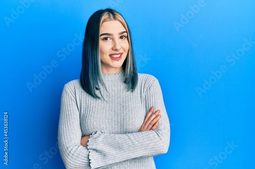 Young modern girl wearing casual sweater happy face smiling with crossed arms looking at the camera. positive person.