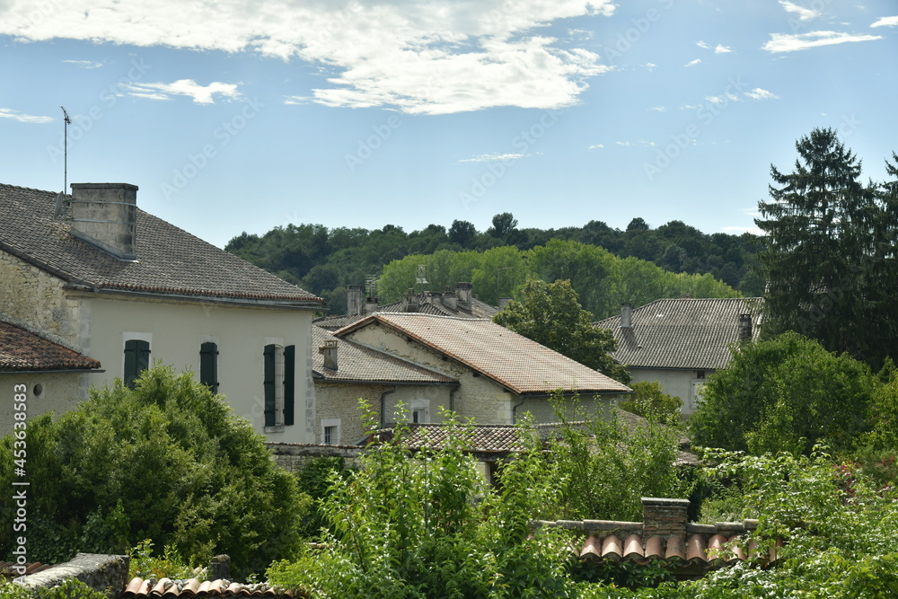 Les toits des maisons et la colline boisée au Bourg de Champagne au Périgord Vert
