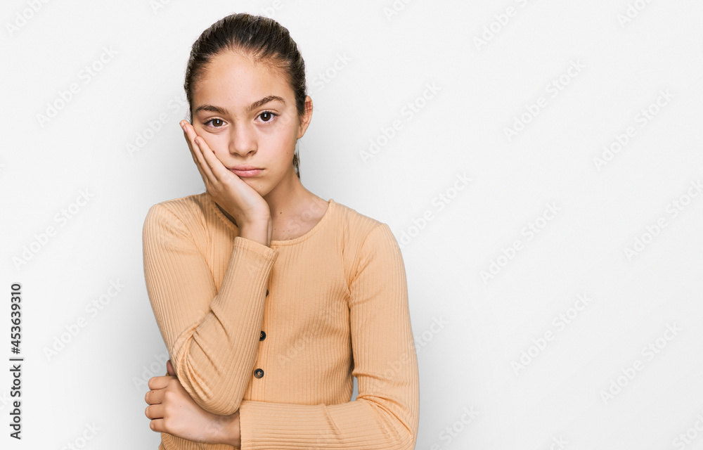 Beautiful brunette little girl wearing casual sweater thinking looking tired and bored with depression problems with crossed arms.