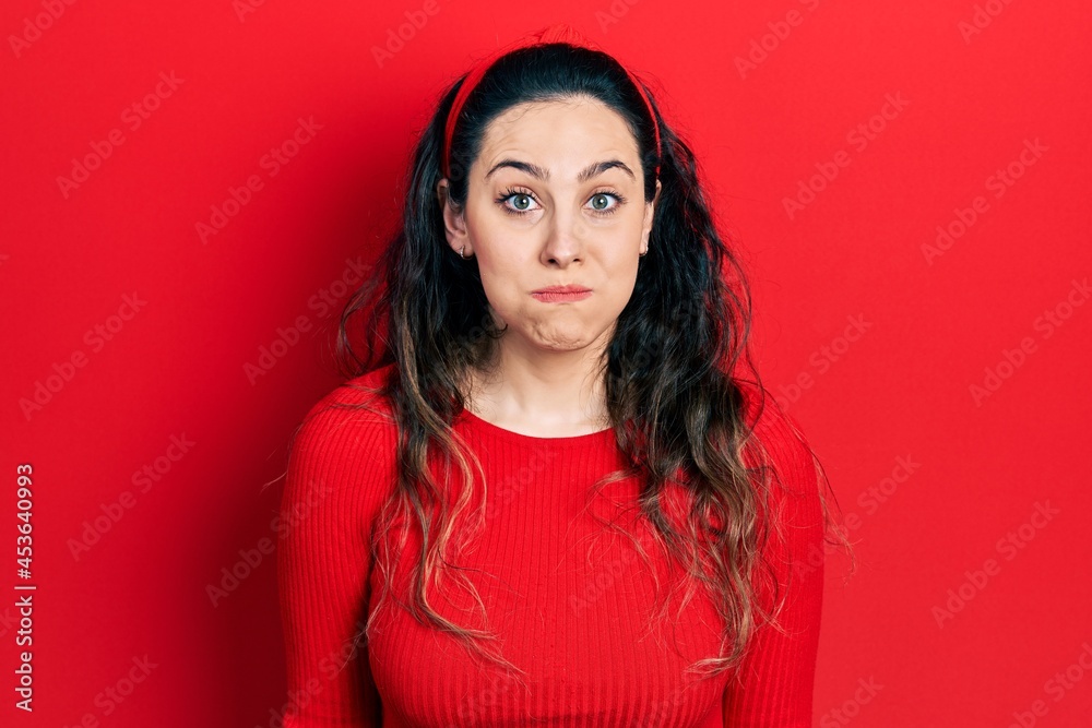 Young hispanic woman wearing casual clothes puffing cheeks with funny face. mouth inflated with air, crazy expression. Young hispanic woman wearing casual clothes puffing cheeks with funny face. mouth inflated with air, crazy expression.