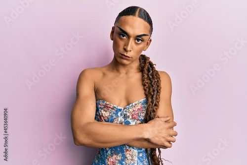 Hispanic man wearing make up and long hair wearing elegant corset skeptic and nervous, disapproving expression on face with crossed arms. negative person.