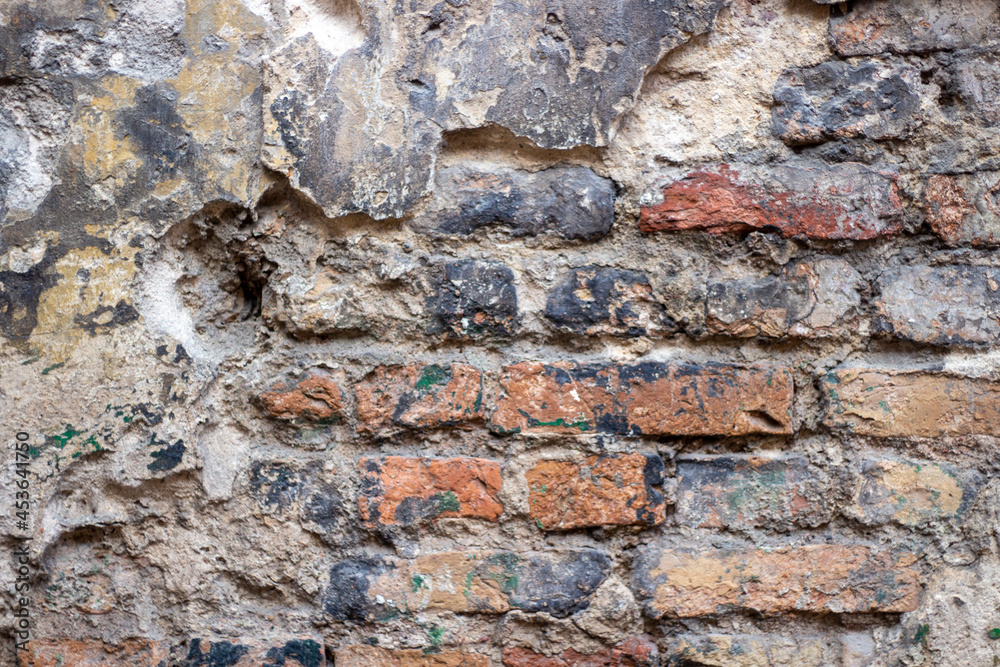 Old brick wall with peel stucco texture. Retro vintage worn wall background. Decayed cracked rough abstract wall surface Old brick wall with peel stucco texture. Retro vintage worn wall background. Decayed cracked rough abstract wall surface