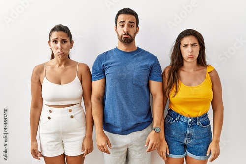Group of young hispanic people standing over isolated background depressed and worry for distress  crying angry and afraid. sad expression.