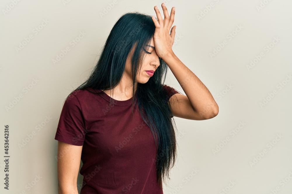 Young hispanic girl wearing casual t shirt surprised with hand on head for mistake, remember error. forgot, bad memory concept. Young hispanic girl wearing casual t shirt surprised with hand on head for mistake, remember error. forgot, bad memory concept.
