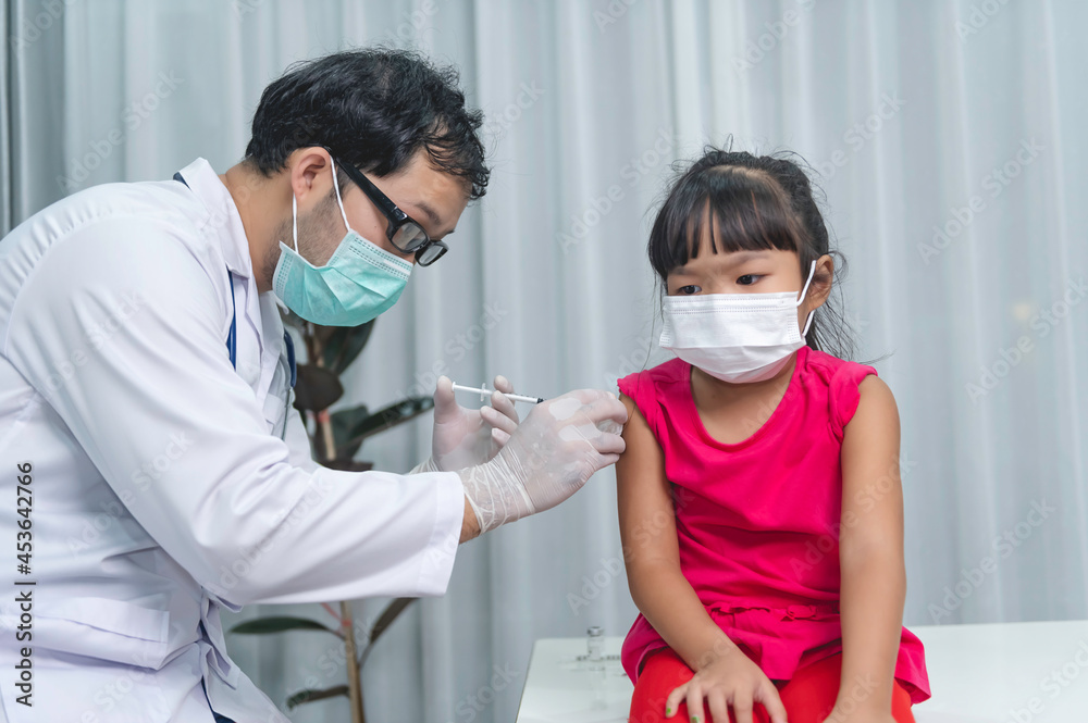Asian doctor injection vaccine for protecting virus covid-19 to a girl wear medical mask,People are Girls are vaccinated against influenza every year.