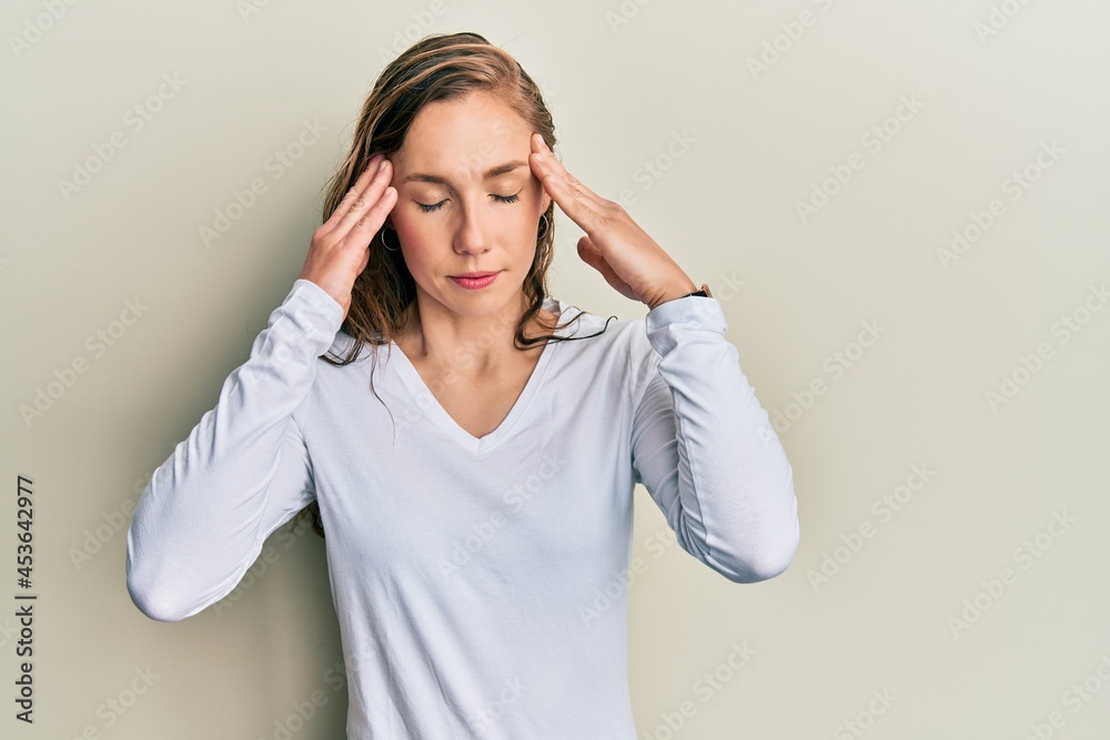 Young blonde woman wearing casual clothes with hand on head for pain in head because stress. suffering migraine. Young blonde woman wearing casual clothes with hand on head for pain in head because stress. suffering migraine.