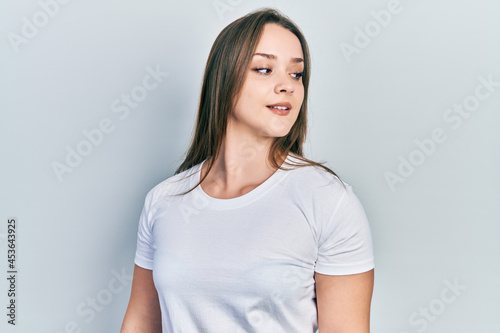 Young hispanic girl wearing casual white t shirt looking to side, relax profile pose with natural face and confident smile. © Krakenimages.com