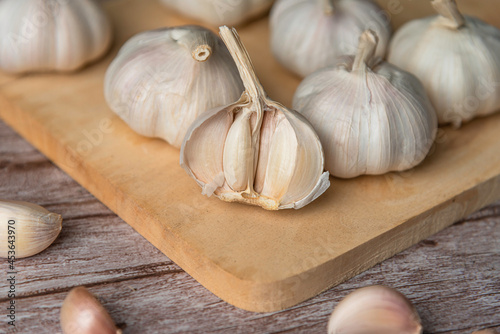 Garlic bulb on wooden chopping board.