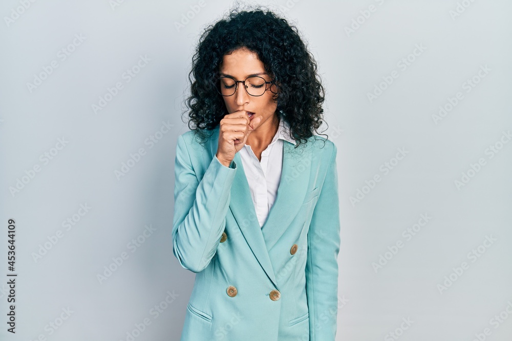 Young latin girl wearing business clothes and glasses feeling unwell and coughing as symptom for cold or bronchitis. health care concept. Young latin girl wearing business clothes and glasses feeling unwell and coughing as symptom for cold or bronchitis. health care concept.