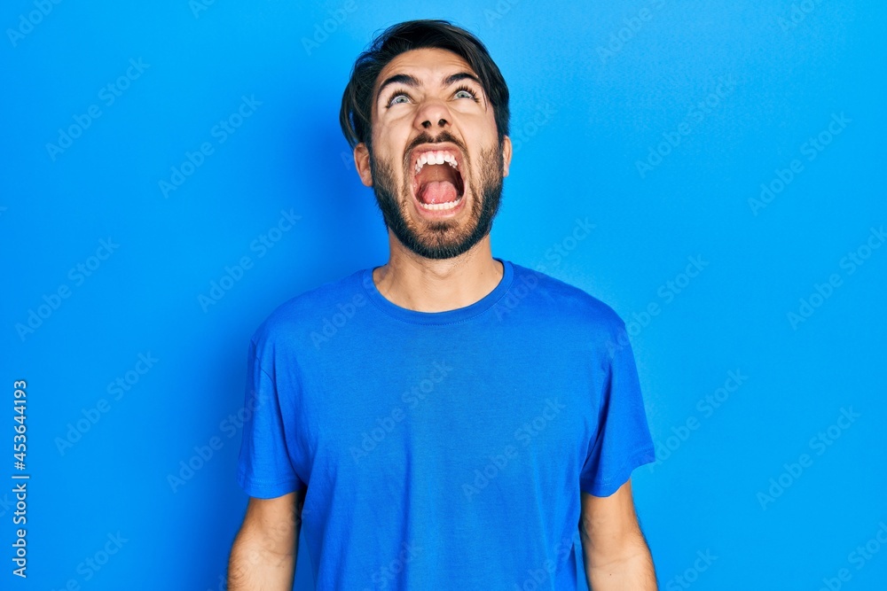 Young hispanic man wearing casual clothes angry and mad screaming frustrated and furious, shouting with anger. rage and aggressive concept. Young hispanic man wearing casual clothes angry and mad screaming frustrated and furious, shouting with anger. rage and aggressive concept.