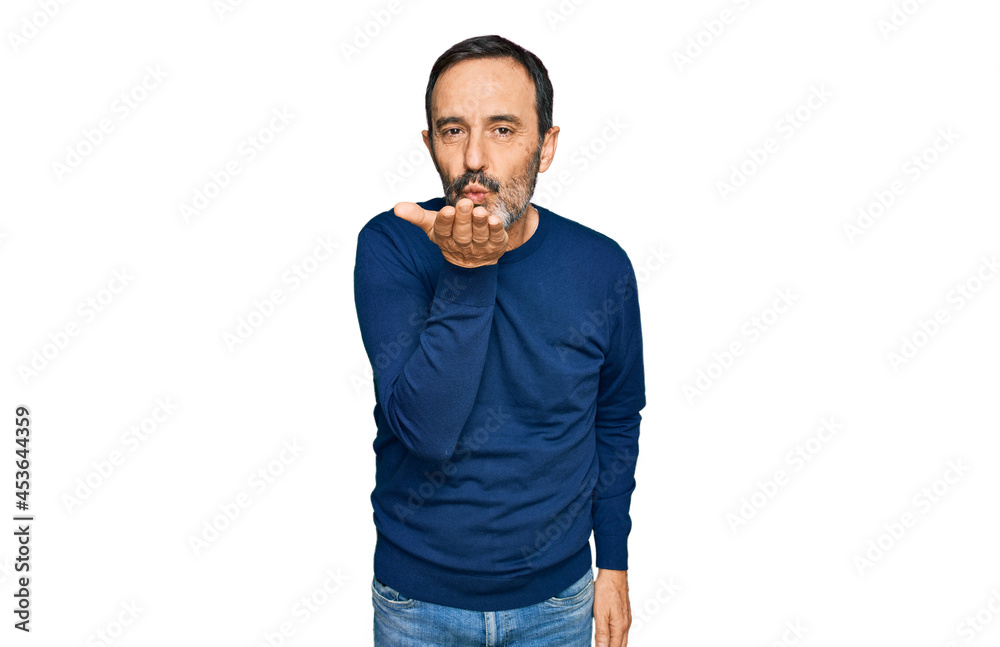 Middle age hispanic man wearing casual clothes looking at the camera blowing a kiss with hand on air being lovely and sexy. love expression. Middle age hispanic man wearing casual clothes looking at the camera blowing a kiss with hand on air being lovely and sexy. love expression.