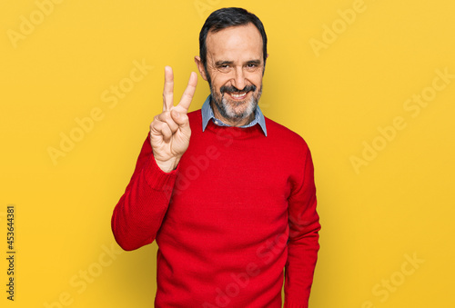 Middle age hispanic man wearing casual clothes showing and pointing up with fingers number two while smiling confident and happy.