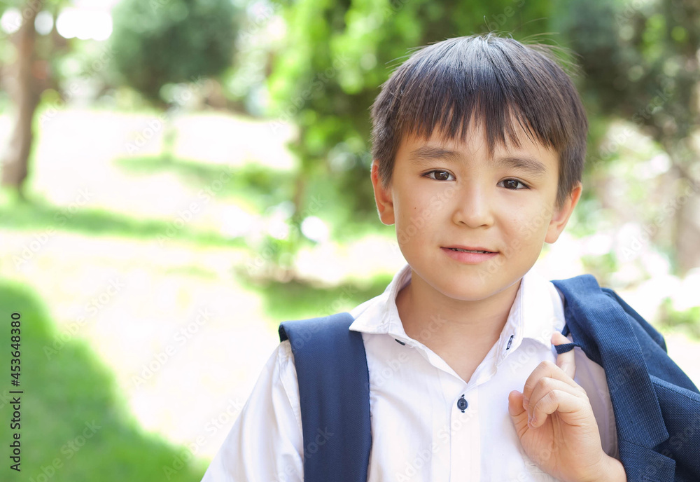 Happy asian boy in a uniform with a backpack outdoors. Back to school. Happy asian boy in a uniform with a backpack outdoors. Back to school.