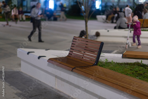 A modern bench on a city street at night in a park.