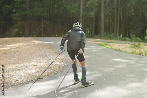 Men ride roller skis in the park.Fitness on the street. photo