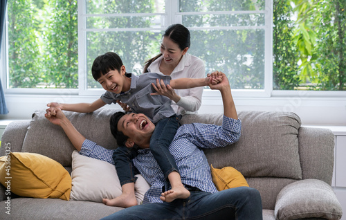 Happy family with father , mother and sons spending time together enjoying on weekend having fun leisure activity in living room