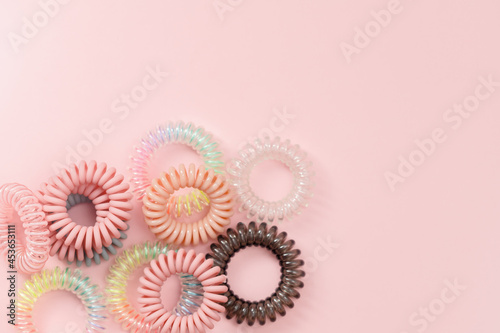 Spiral hair rubber bands on pink background for feminine accessories concept