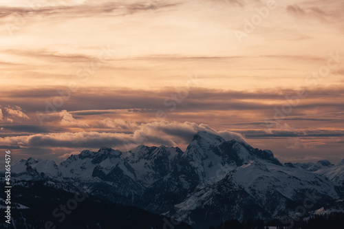 Dramatic colors effect of winter panorama of Marmolada Peak at sunset with sunlit clouds. Fiorentina Valley, Dolomites, Italy
