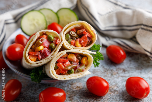 Organic vegan vegetable wraps. Organic vegan vegetable wraps filled with corn, red beat, tomatoes, beans in a bowl on a table top.
