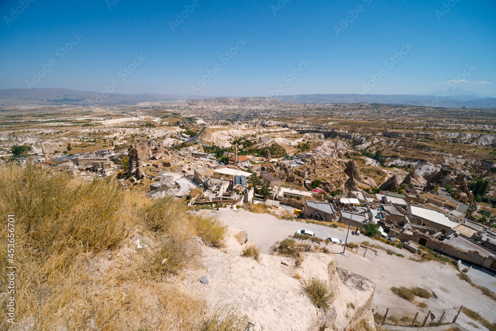 Uchisar Castle. Tourist at the top of the fortress, mountains, view of Cappadocia. Traveler at Destinaton. Turkey Vacation and Tour Concept Summer day.