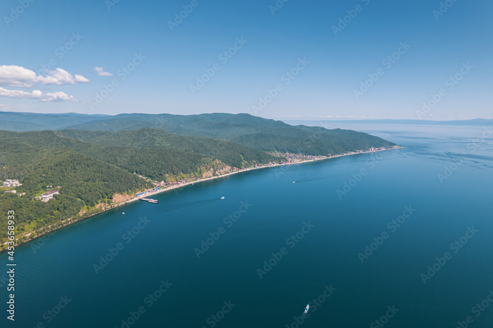 Lake Baikal is a marvelous blue jewel framed by scenic mountains and forests. Epic cinematic aerial view Lake Baikal. Aerial view of blue lake and green forests. Lake Baikal is a marvelous blue jewel framed by scenic mountains and forests. Epic cinematic aerial view Lake Baikal. Aerial view of blue lake and green forests.
