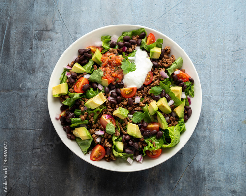Beef Taco salad with romaine lettuce, avocado, tomato salsa, black bean and tortilla chips. Mexican healthy food