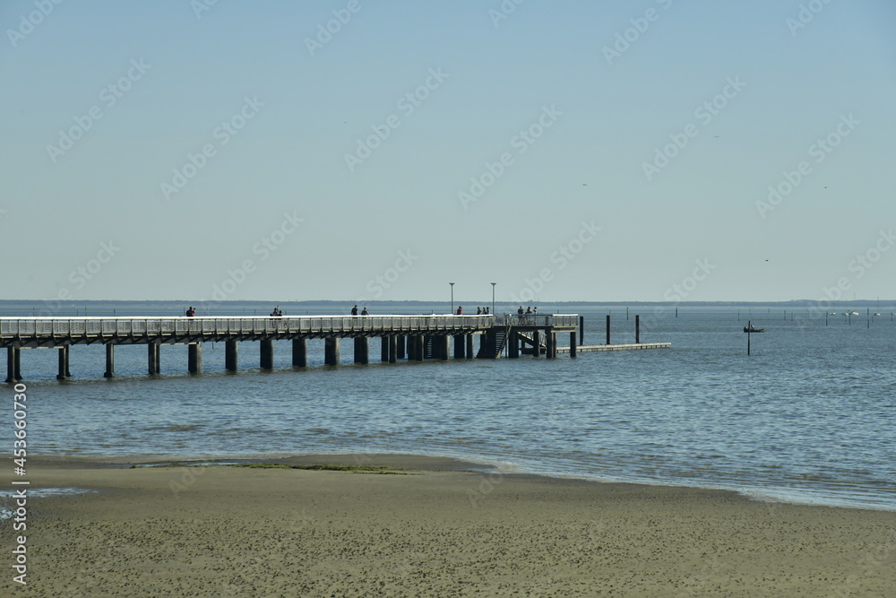 L'immense plage à marée basse et la jetée-promenade à Andernos-les-Bains dans la baie d'Arcachon L'immense plage à marée basse et la jetée-promenade à Andernos-les-Bains dans la baie d'Arcachon