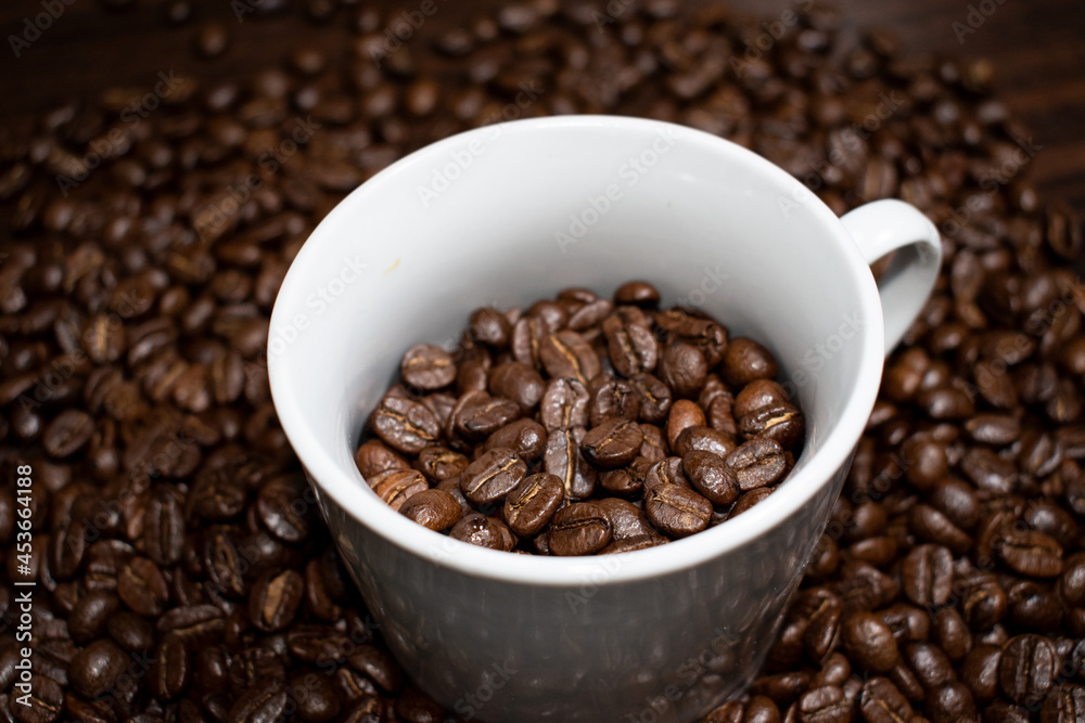 Cup of coffee full of coffee beans.