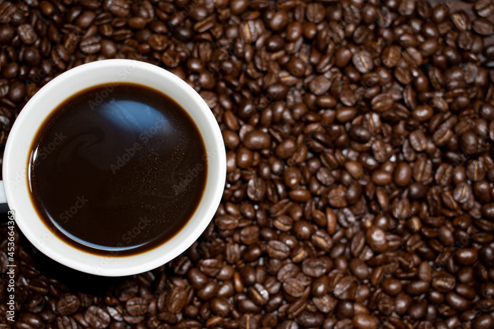 Coffee cup top view on roasted coffee beans background Coffee cup top view on roasted coffee beans background
