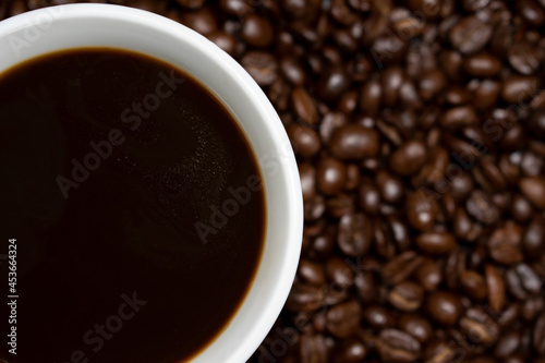 Coffee cup top view on roasted coffee beans background