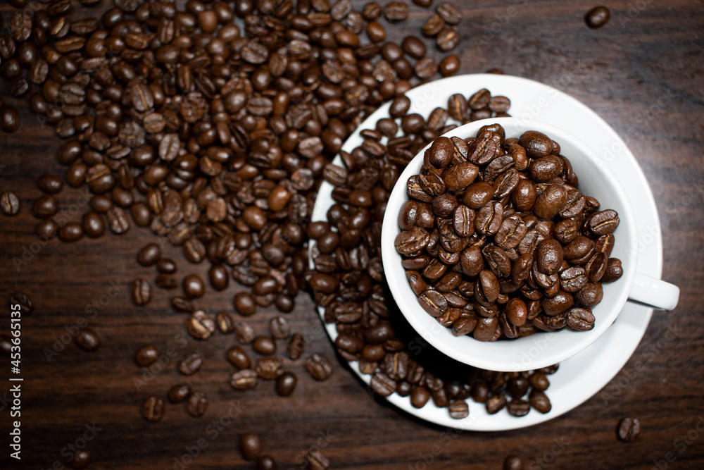 Fototapeta premium Cup of coffee full of coffee beans.