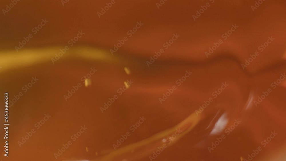 Water moves in a glass in slow motion. Abstract orange water background. Water moves in a glass in slow motion. Abstract orange water background.