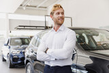 Man smiling happy customer male buyer client wear white shirt hold hand crossed folded choose auto want buy new car automobile in showroom vehicle dealership store motor show indoor. Sales concept