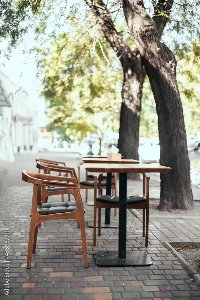 Outdoor empty street restaurant with wood stile chairs. Coronavirus crisis
