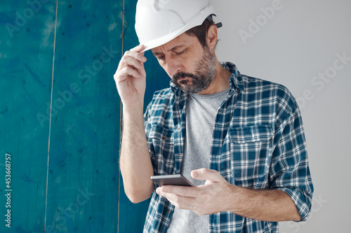 Construction engineer using smart phone on a morning break