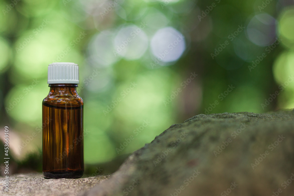 Essential oil in bottle on stone. Bokeh nature background, copy space. Natural Medicine. Blur nature background. Essential oil in bottle on stone. Bokeh nature background, copy space. Natural Medicine. Blur nature background.