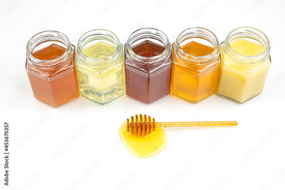 spoon with fresh honey and pollen on the background of jars with different types of honey. organic vitamin food spoon with fresh honey and pollen on the background of jars with different types of honey. organic vitamin food