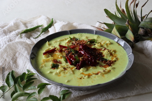 Pineapple pachadi. A yogurt based sweet and spicy curry made with pineapple, coconut, mustard seeds and curd. A side dish for Kerala meals photo