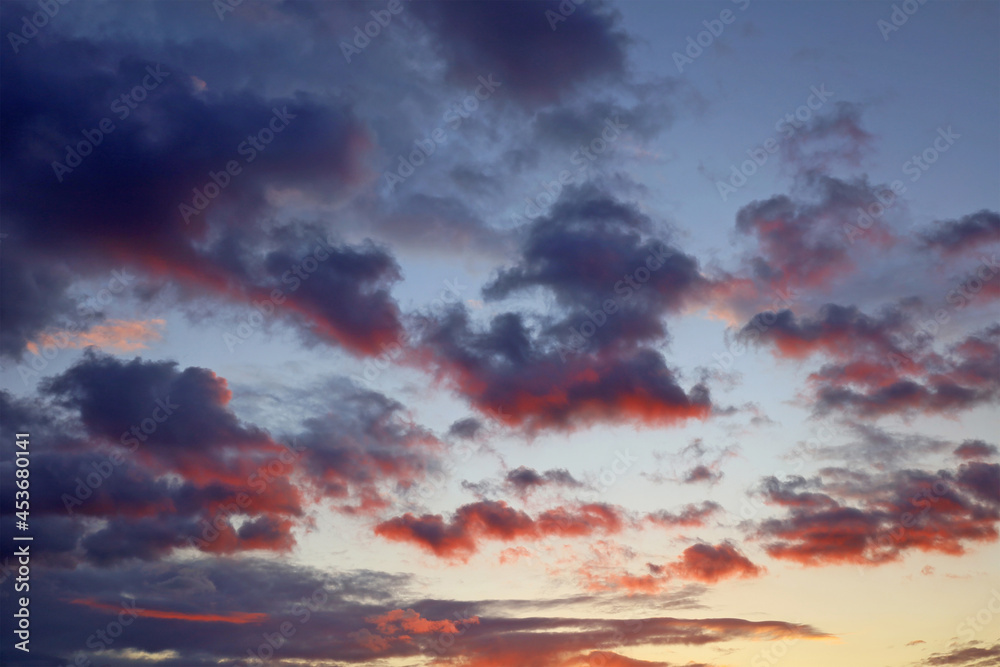 Twilight sky after sunset. Dark purple clouds highlighted in red at the bottom. Colorful dramatic scenery clouds background with place for your text.