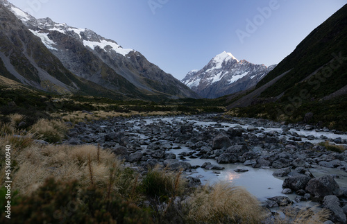 photo of mt cook in new zealand with a river in the foreground.