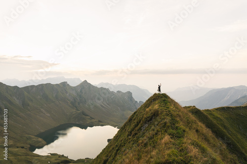 eine person auf der spitze eines berges mit wundervoller aussicht auf einen bergsee in deutschland © thomas