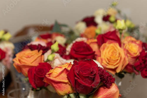Multiple bouquets of red and yellow roses arranged in beautiful bunches.