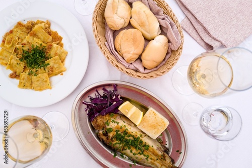 Flat lay of Italian food on the table, fish, pasta and wine